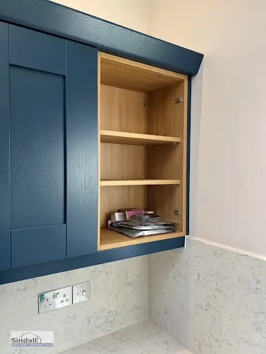 Navy wall cabinet with an oak-lined open shelf section above a stone-effect splashback